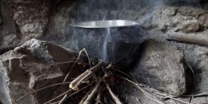 photograph of a cooking stove with smoke from burning wood